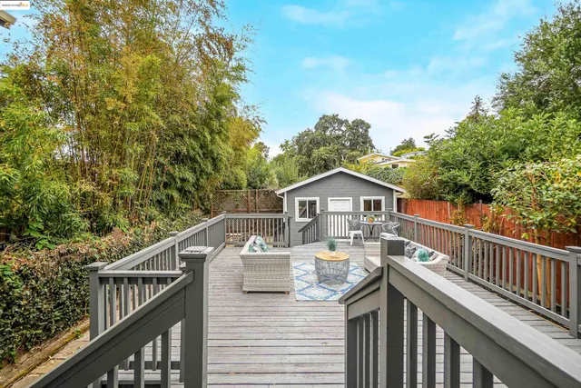 a view of a roof deck with wooden fence and trees