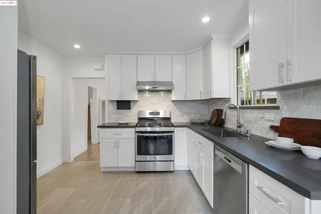 a kitchen with stainless steel appliances granite countertop a stove a sink and a refrigerator