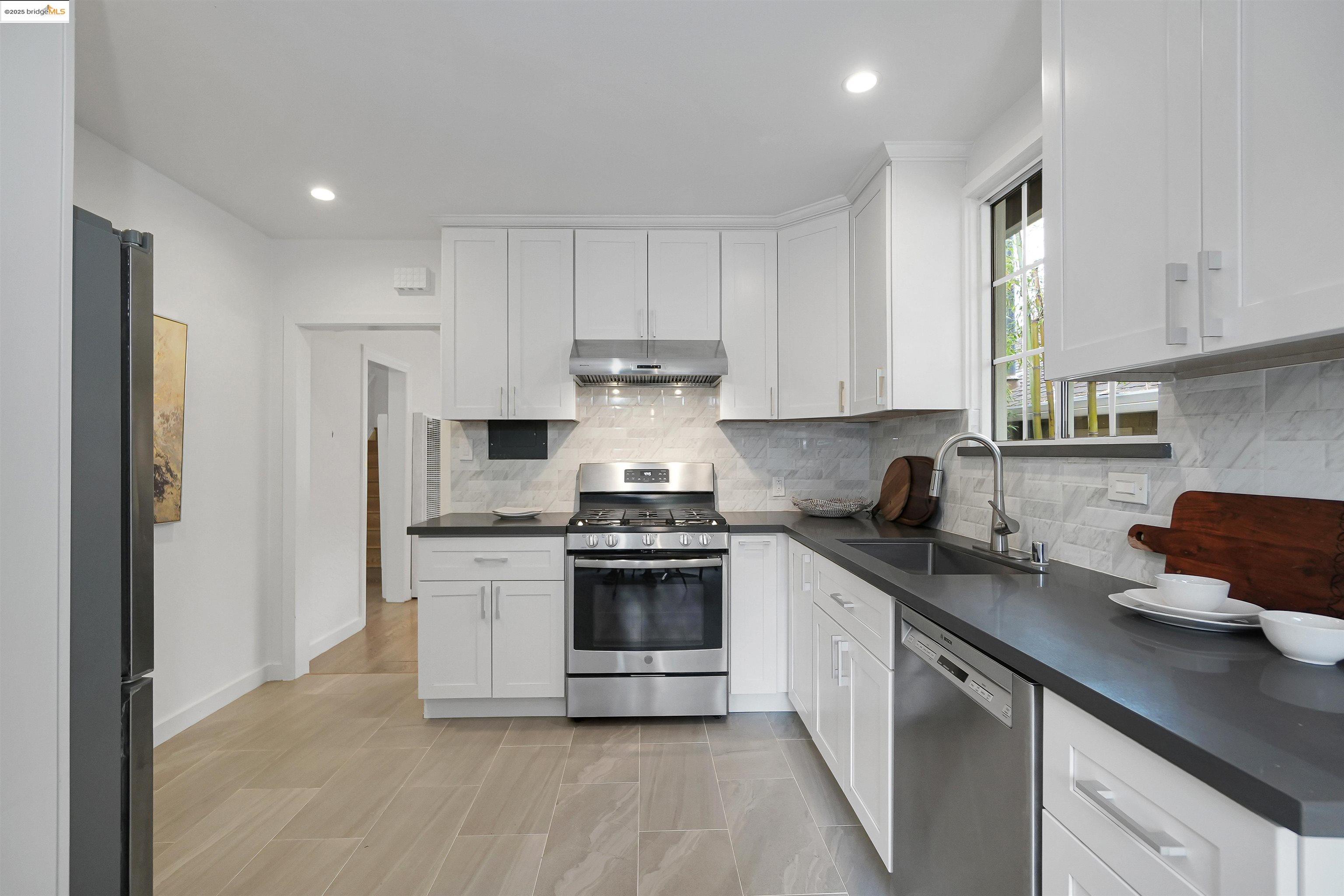 3911 Vale Avenue Oakland, CA 94619 - Photo 4 of 45 a kitchen with stainless steel appliances granite countertop a stove a sink and a refrigerator