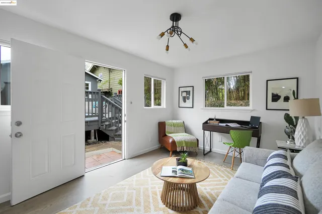 a living room with furniture kitchen view and a window