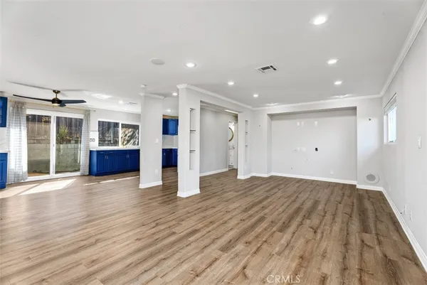 a view of empty room with wooden floor and windows