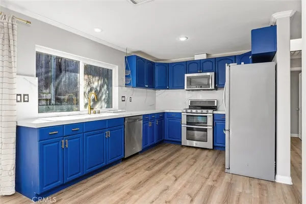 a kitchen with stainless steel appliances granite countertop a refrigerator stove and sink