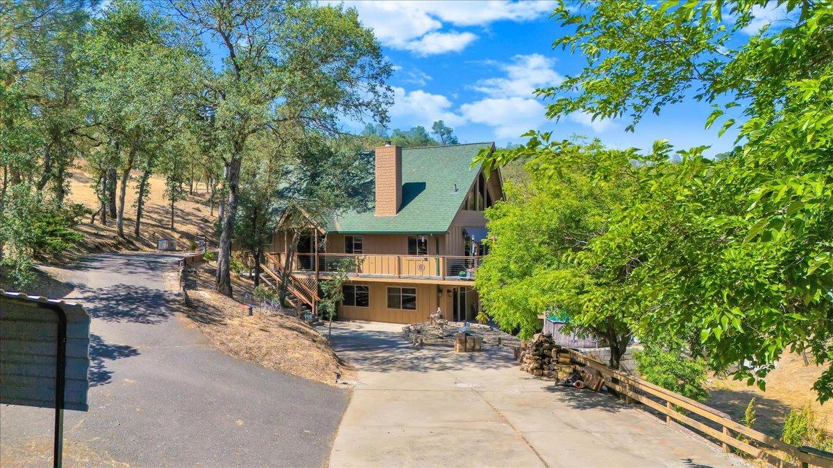 1499 Sawmill Road, Unit 594 Copperopolis, CA 95228 - Photo 7 of 98 a view of a brick house with large windows and a tree