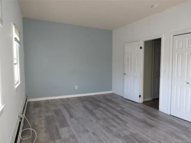 an empty room with wooden floor and a window