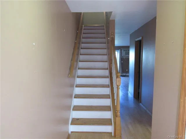 a view of a hallway with wooden floor and entryway