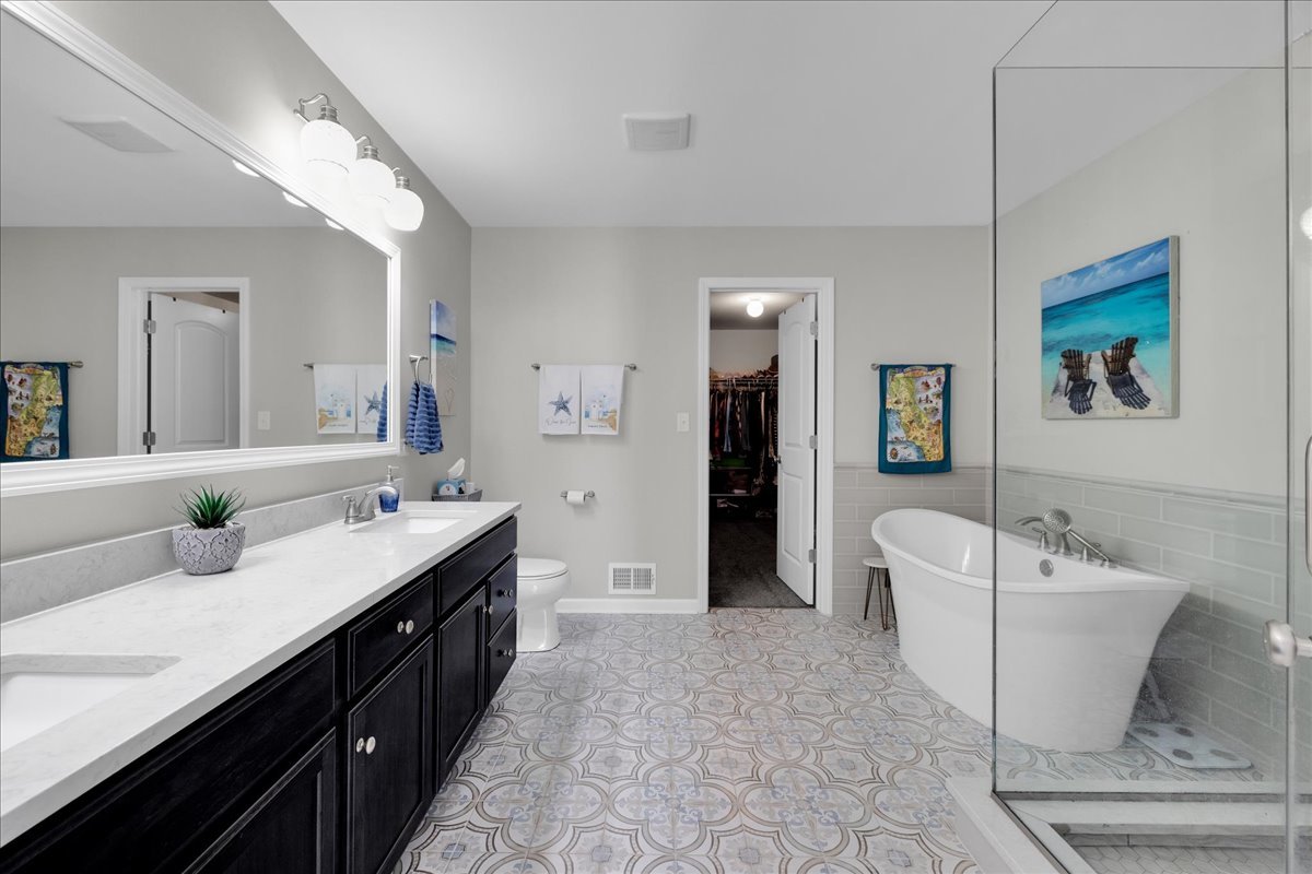 435 Fawn Lane Oswego, IL 60543 - Photo 26 of 47 a spacious bathroom with a double vanity sink a mirror and a bathtub