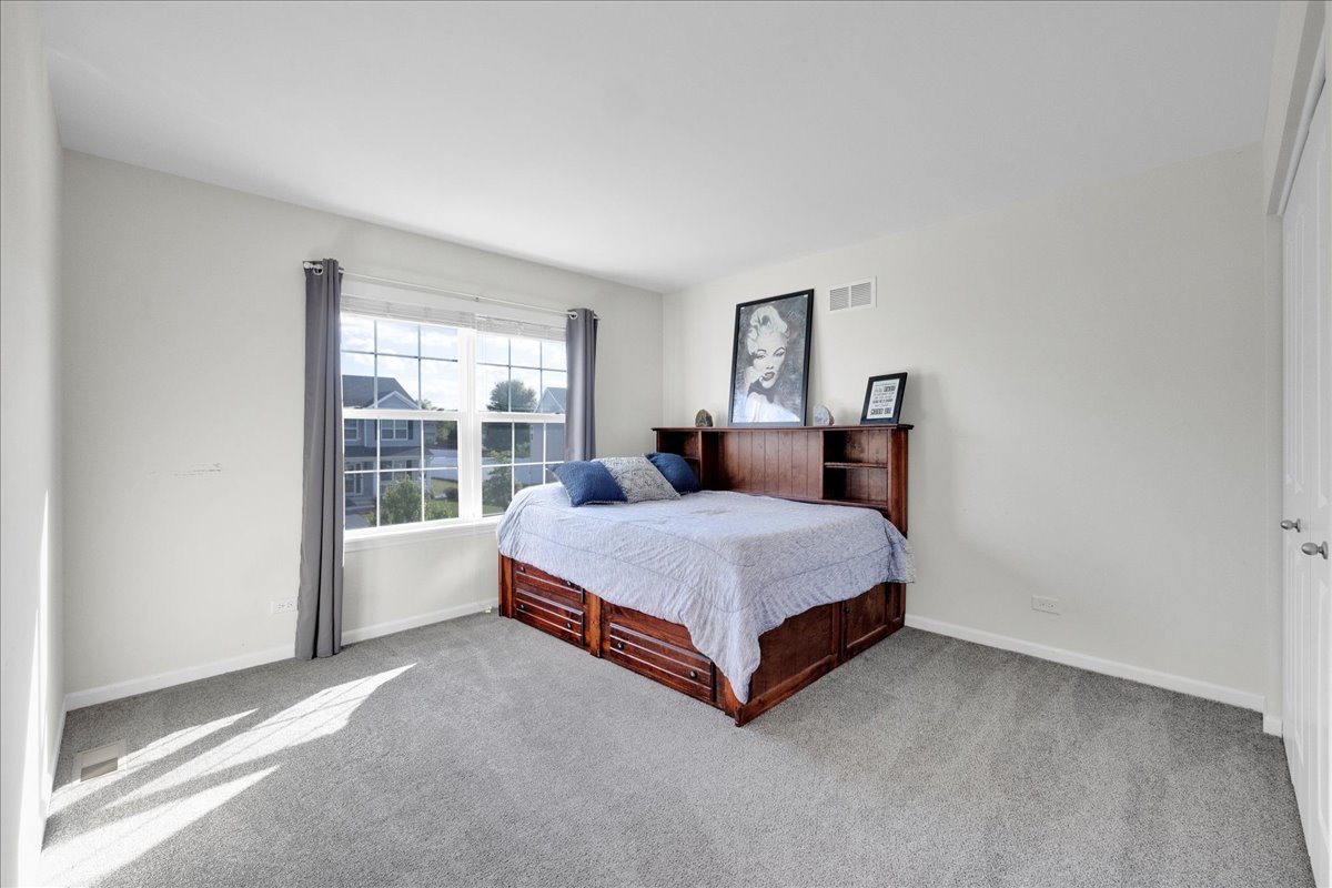 435 Fawn Lane Oswego, IL 60543 - Photo 32 of 47 a bed sitting in a bedroom next to a window