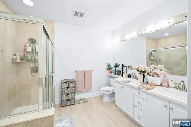 a bathroom with a double vanity sink mirror and shower