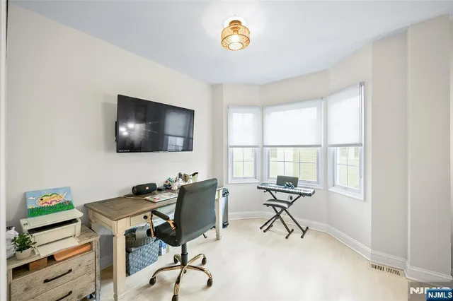 a view of a workspace with furniture and a window