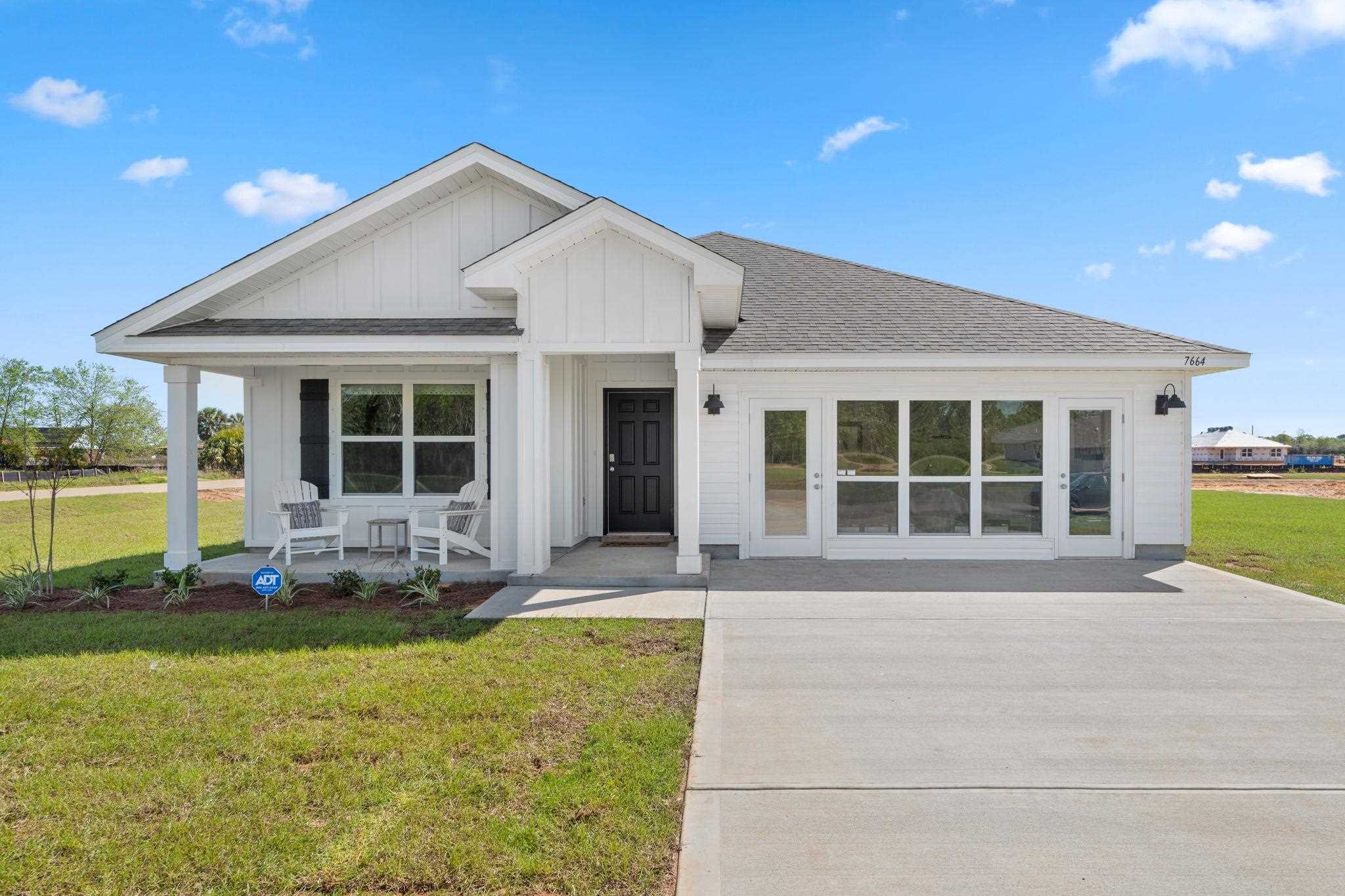 7535 Saddlebrook Avenue Pace, FL 32571 - Photo 1 of 15 a front view of a house with a yard and outdoor seating
