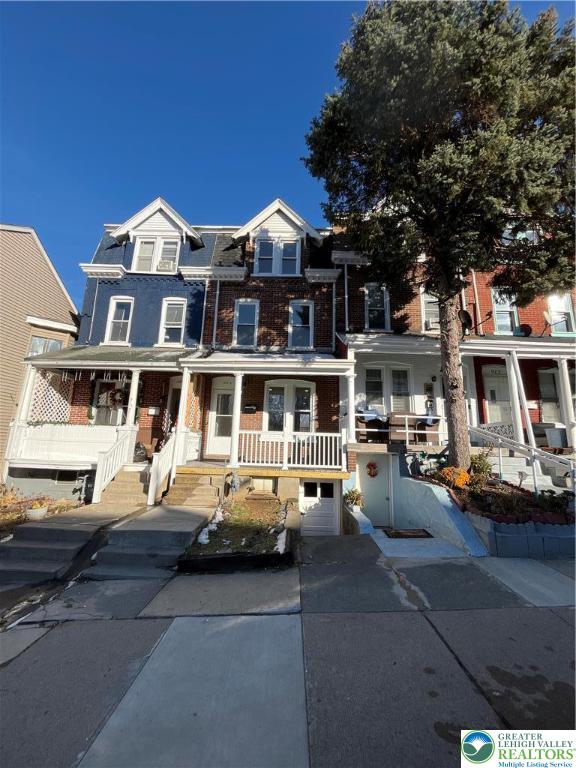 a view of a white building among the street and parked cars