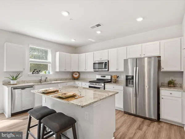 a kitchen with refrigerator cabinets and wooden floor