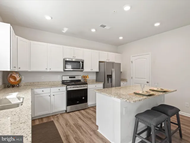 a open dining room with kitchen island a stove a table and chairs