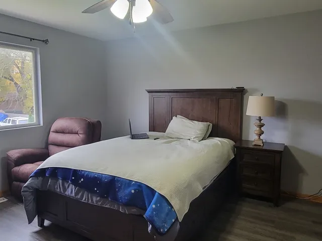 a bedroom with a bed lamp and a window