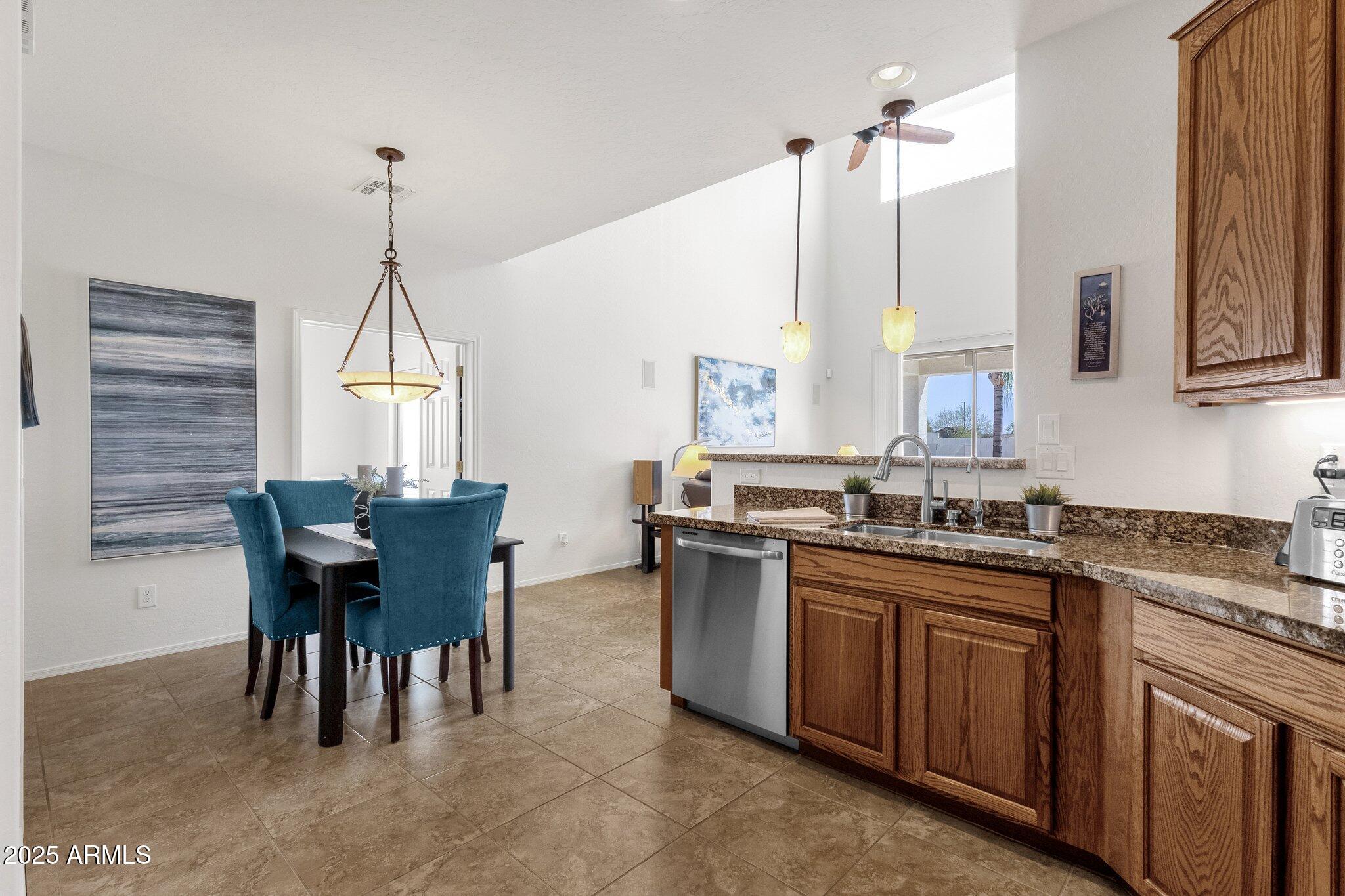 2417 West Apache Rain Road Phoenix, AZ 85085 - Photo 11 of 41 a kitchen with granite countertop a sink dining table and chairs
