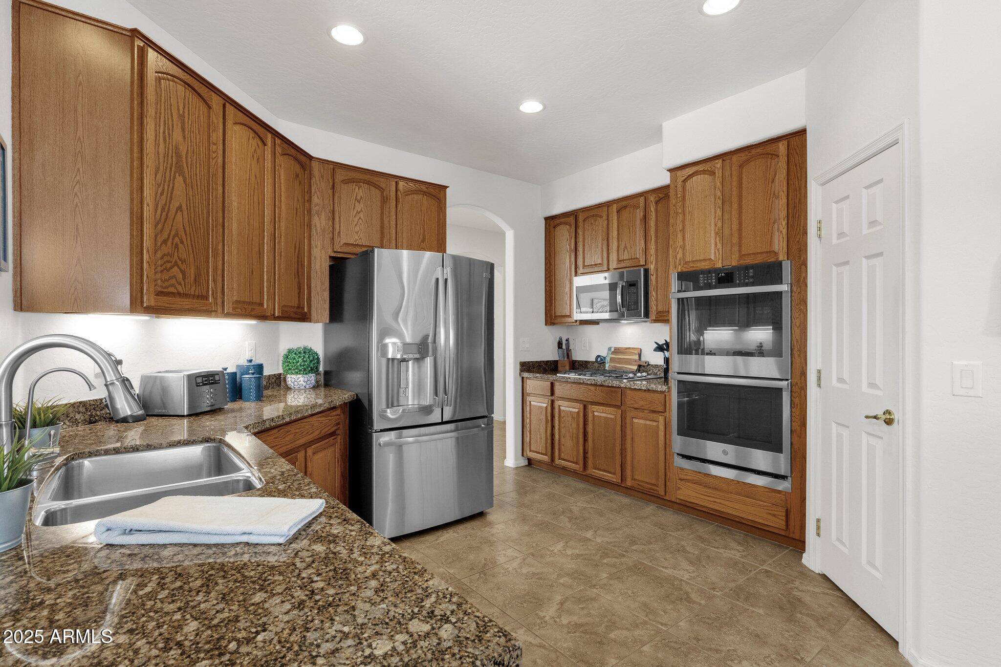2417 West Apache Rain Road Phoenix, AZ 85085 - Photo 12 of 41 a kitchen with stainless steel appliances granite countertop a refrigerator stove and oven