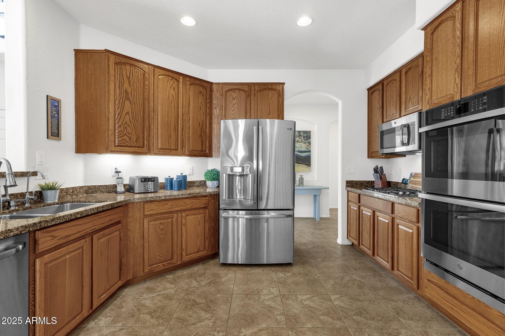 2417 West Apache Rain Road Phoenix, AZ 85085 - Photo 15 of 41 a kitchen with stainless steel appliances granite countertop a refrigerator stove and sink