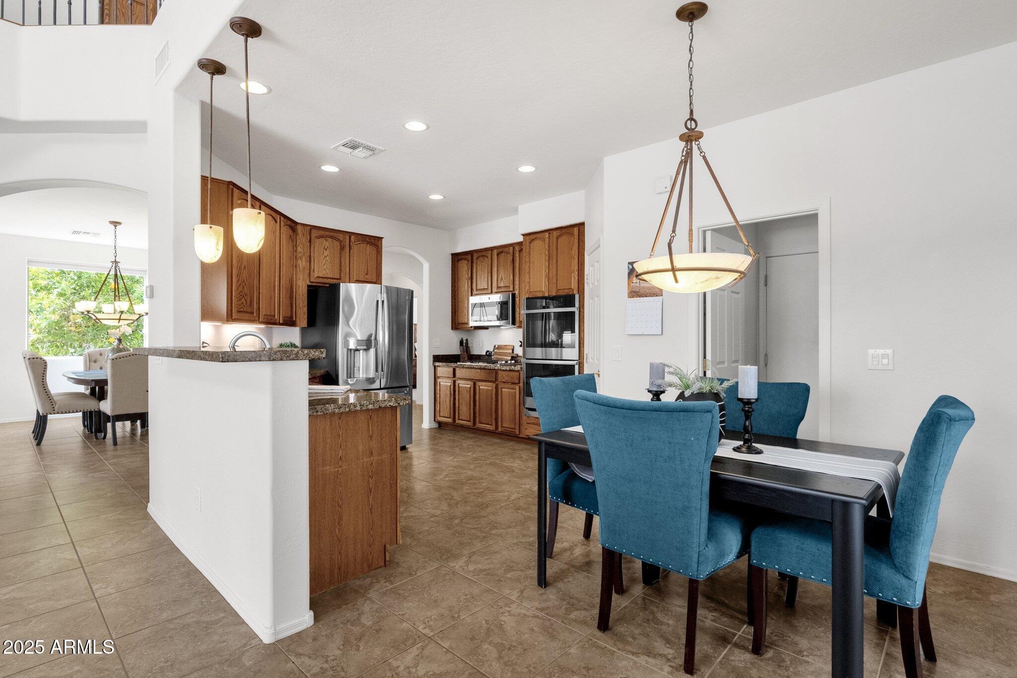 2417 West Apache Rain Road Phoenix, AZ 85085 - Photo 16 of 41 a view of a dining room and livingroom with furniture wooden floor a chandelier