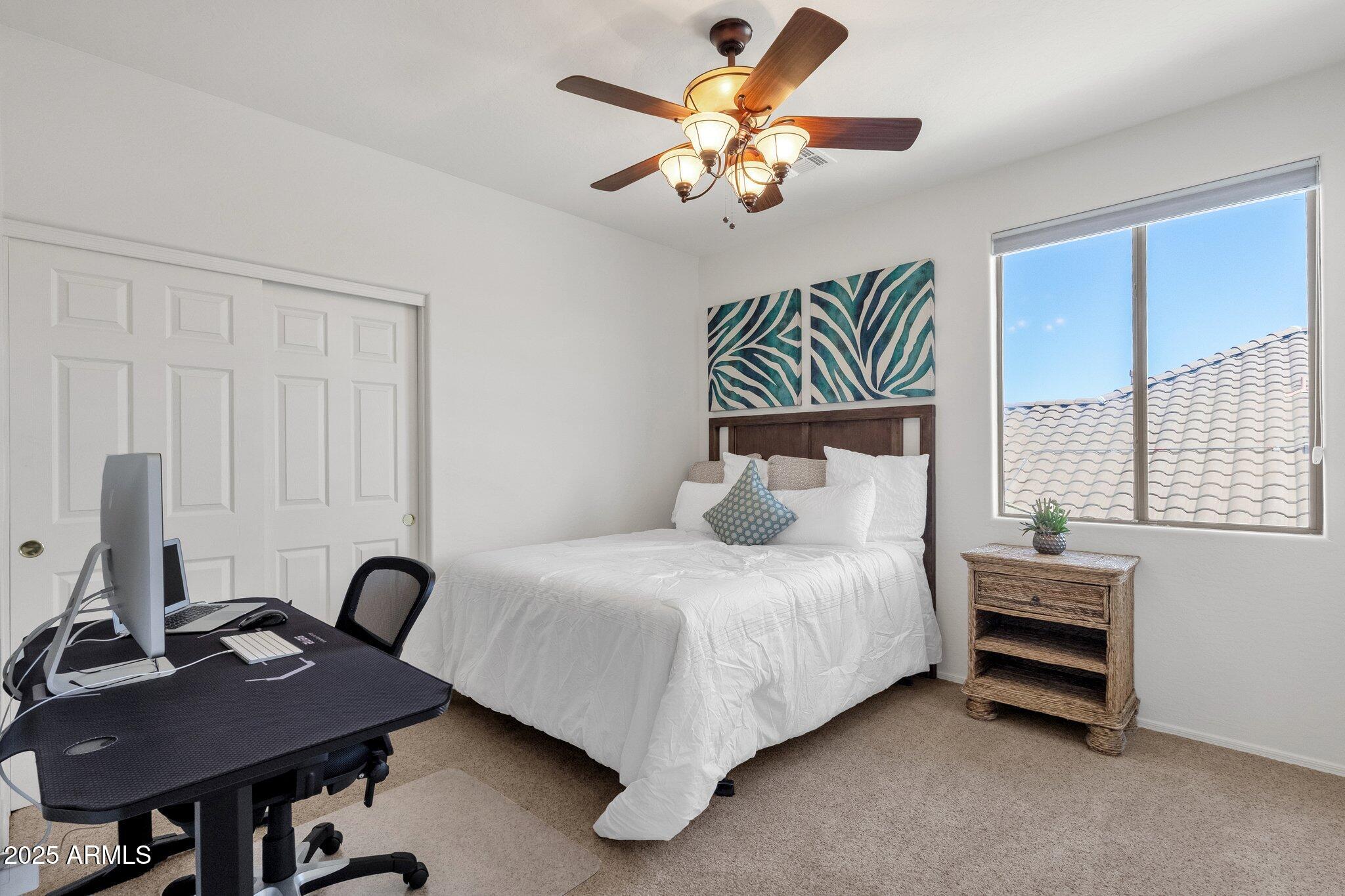 2417 West Apache Rain Road Phoenix, AZ 85085 - Photo 28 of 41 a bedroom with a bed and a chandelier