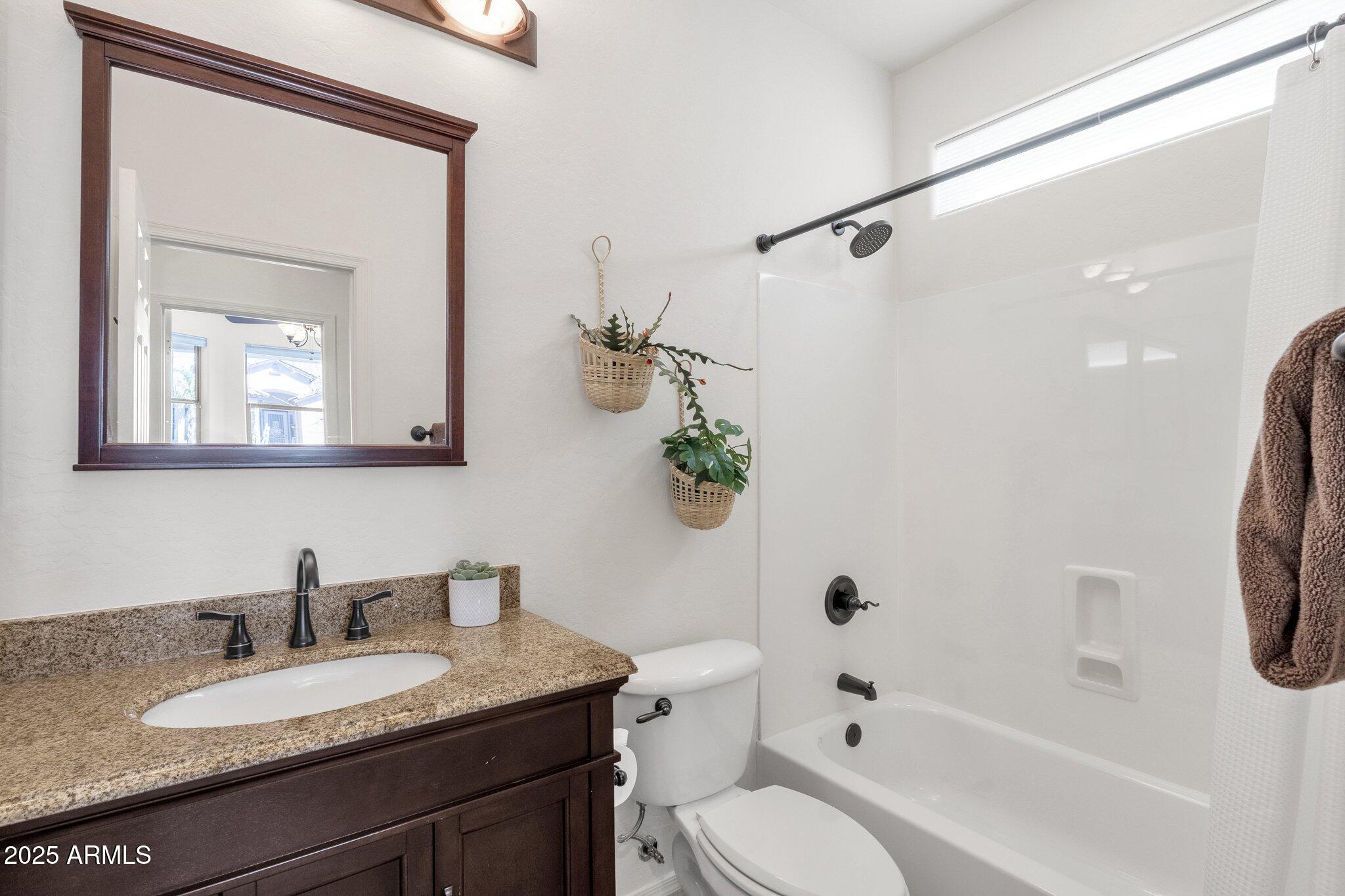 2417 West Apache Rain Road Phoenix, AZ 85085 - Photo 4 of 41 a bathroom with a granite countertop sink a toilet and a mirror