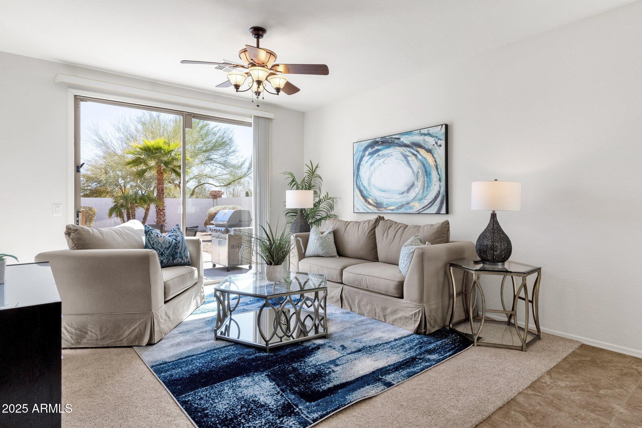 2417 West Apache Rain Road Phoenix, AZ 85085 - Photo 8 of 41 a living room with furniture a chandelier and a large window