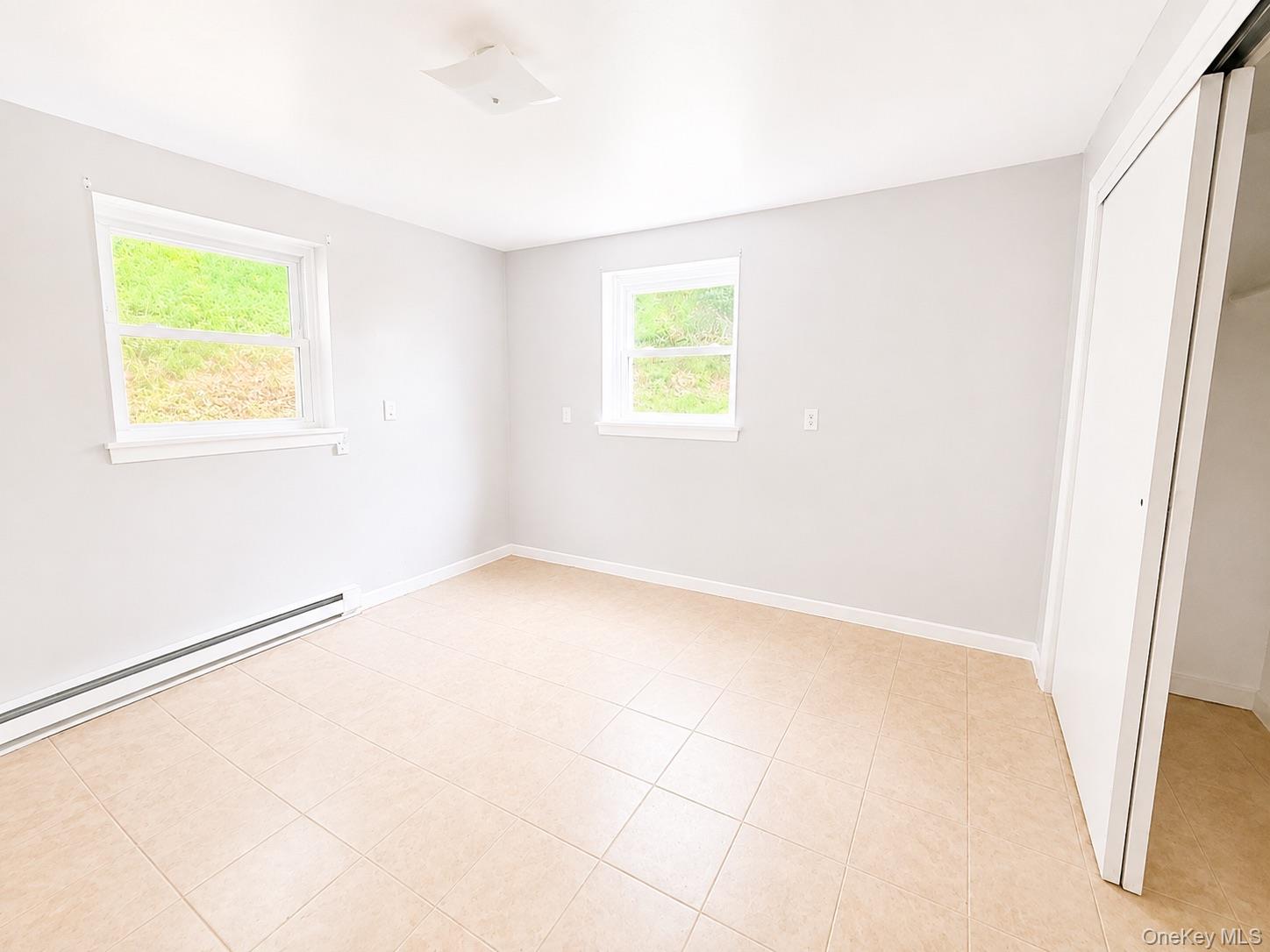43 Glenmere Homesites Road, Unit 1F Florida, NY 10921 - Photo 8 of 14 Neutral-toned tiled flooring, white walls, and two windows with white trim