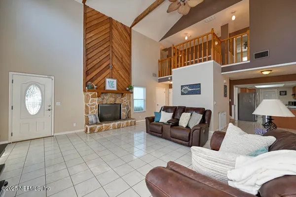 a living room with furniture a fireplace and a flat screen tv