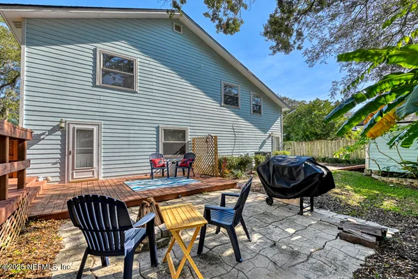 a backyard of a house with barbeque oven table and chairs