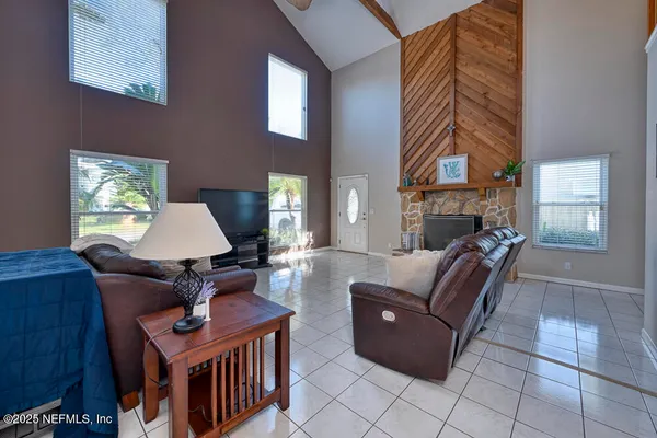 a living room with furniture a window and a flat screen tv