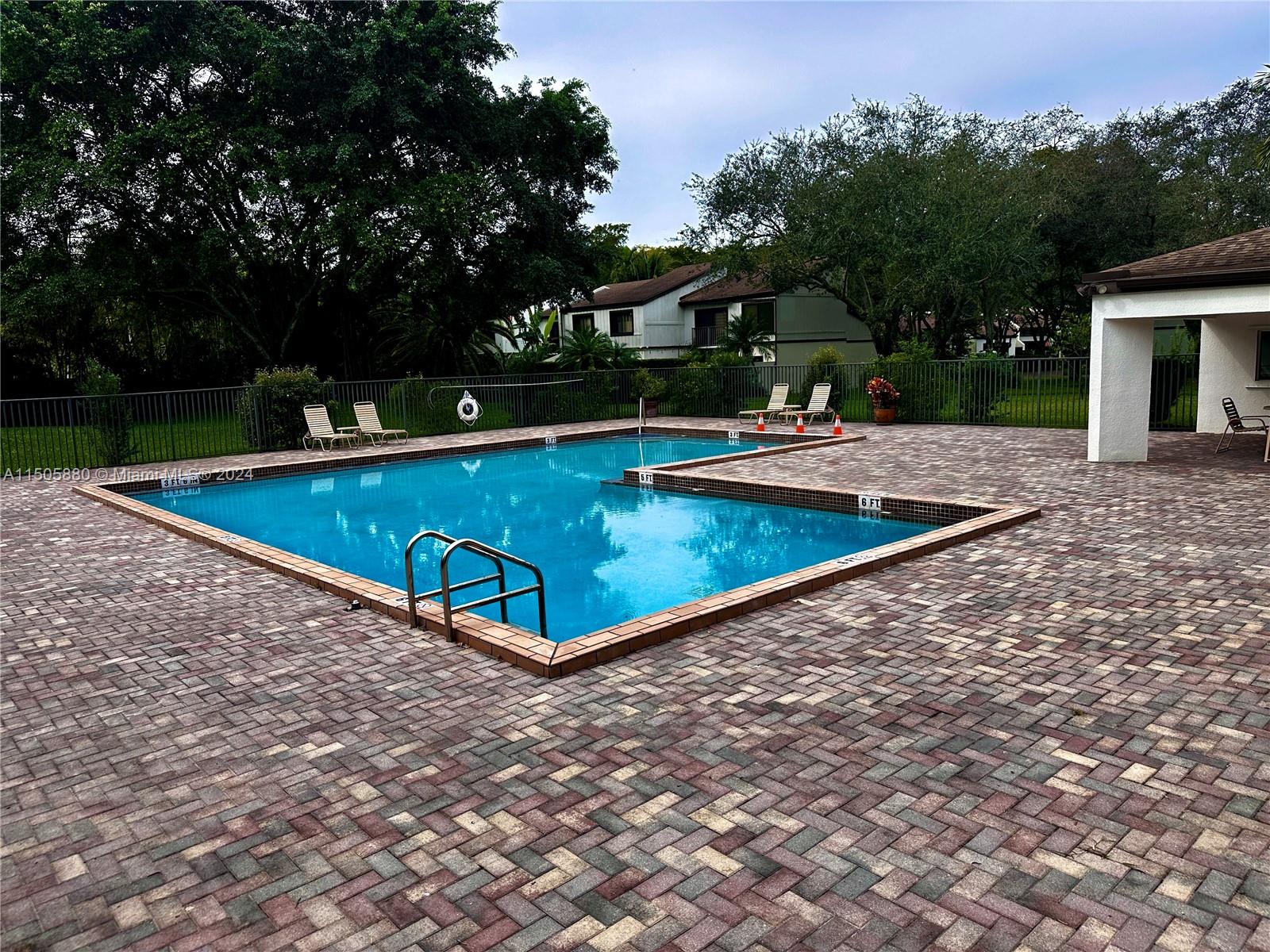 8636 Southwest 94th Street Miami, FL 33156 - Photo 28 of 29 a view of a swimming pool with a bench and trees around