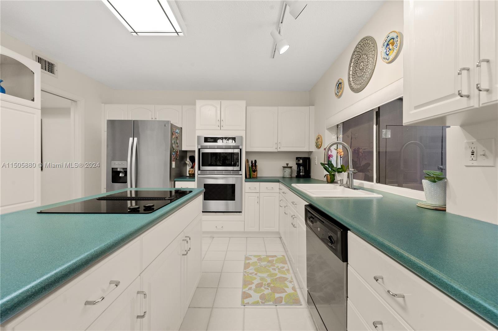 8636 Southwest 94th Street Miami, FL 33156 - Photo 10 of 29 a kitchen with stainless steel appliances granite countertop a sink a stove cabinets and entryway