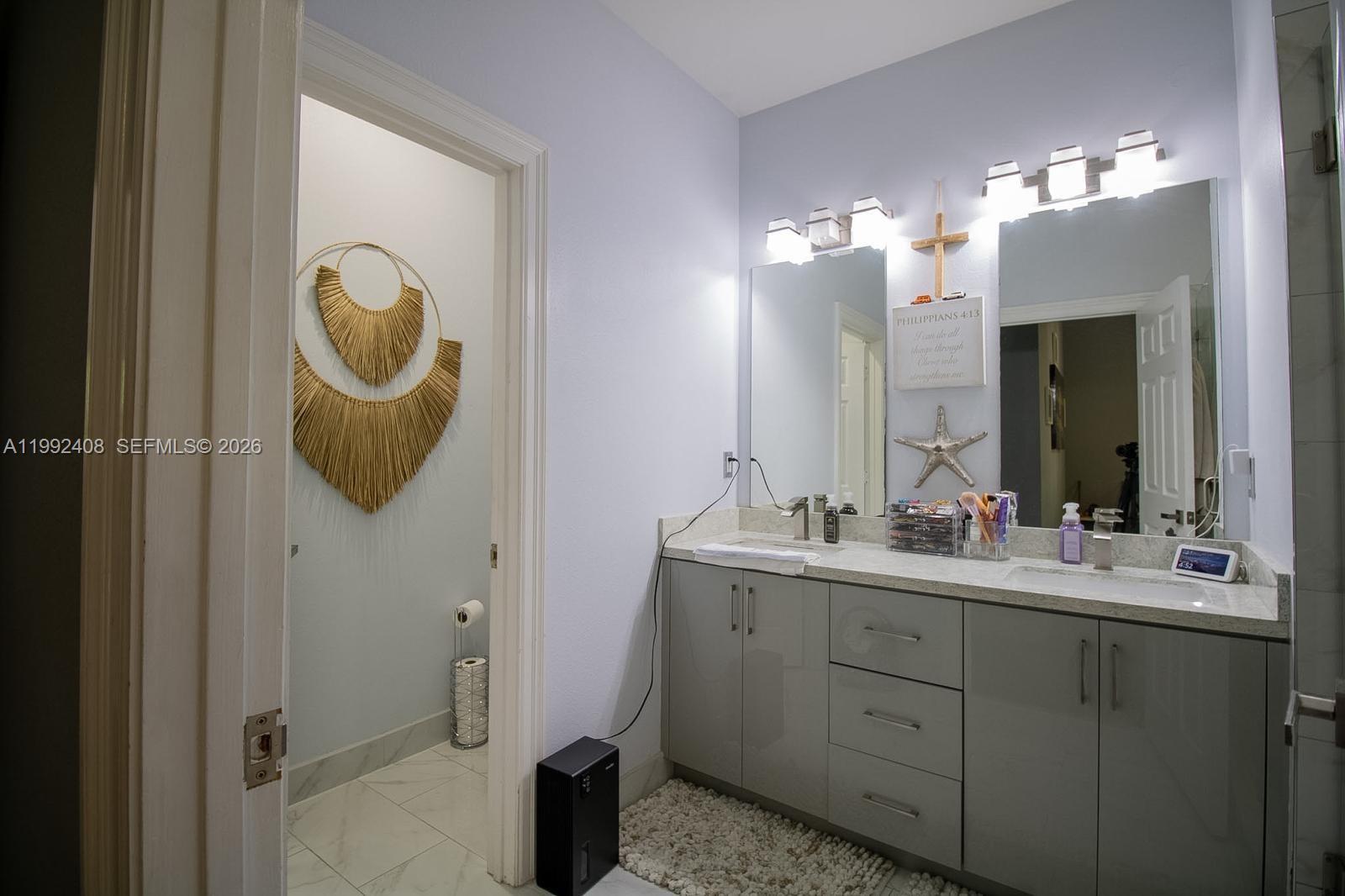 2607 Southwest 99th Way Miramar, FL 33025 - Photo 30 of 50 a bathroom with a double vanity sink and a mirror