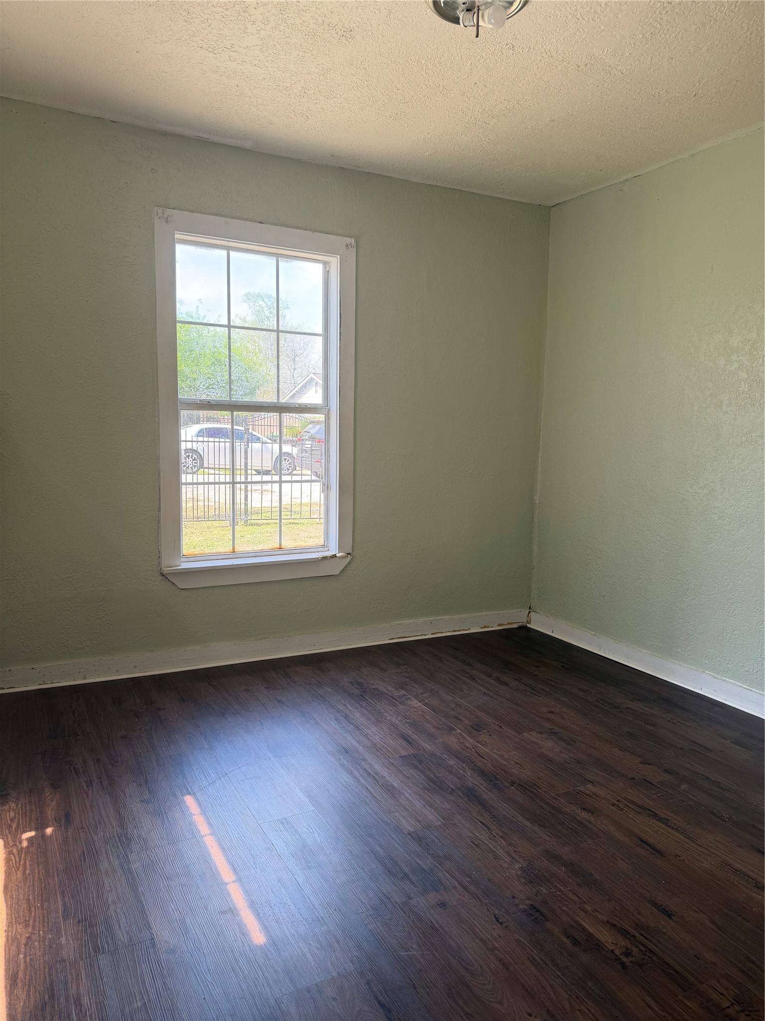 11914 Anchick Street Houston, TX 77076 - Photo 11 of 17 an empty room with wooden floor and windows