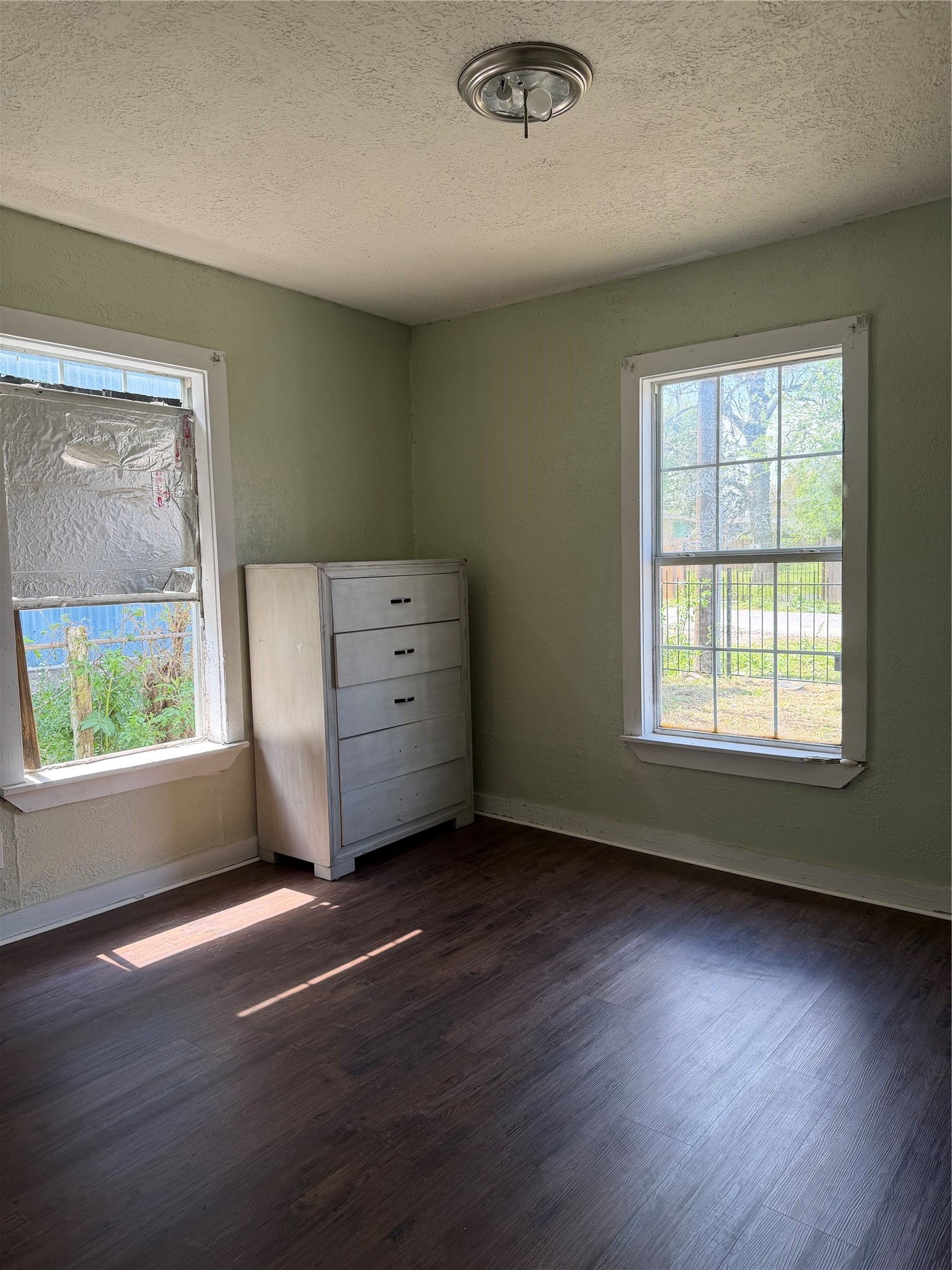11914 Anchick Street Houston, TX 77076 - Photo 12 of 17 an empty room with wooden floor and windows
