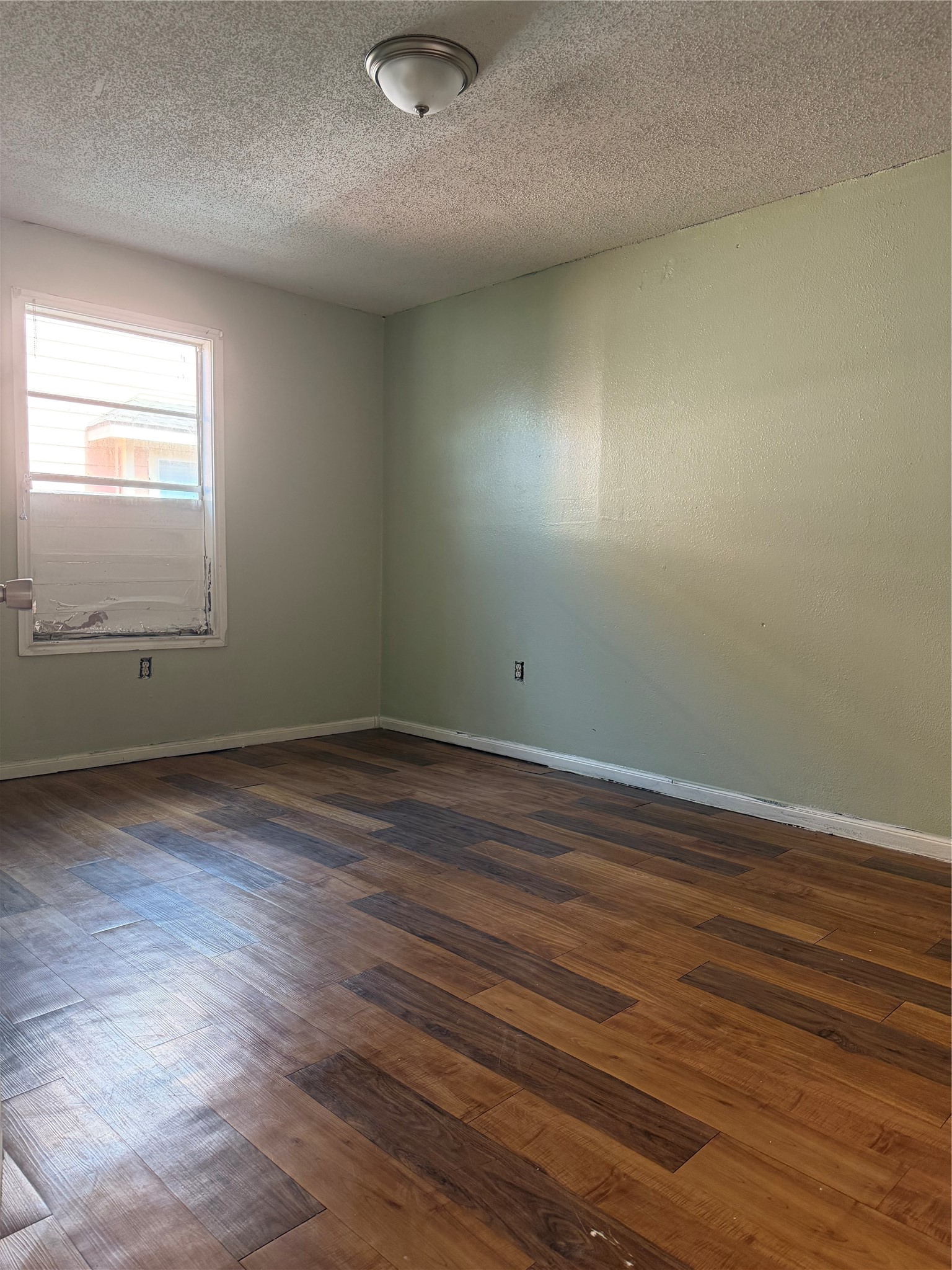11914 Anchick Street Houston, TX 77076 - Photo 13 of 17 an empty room with wooden floor and windows