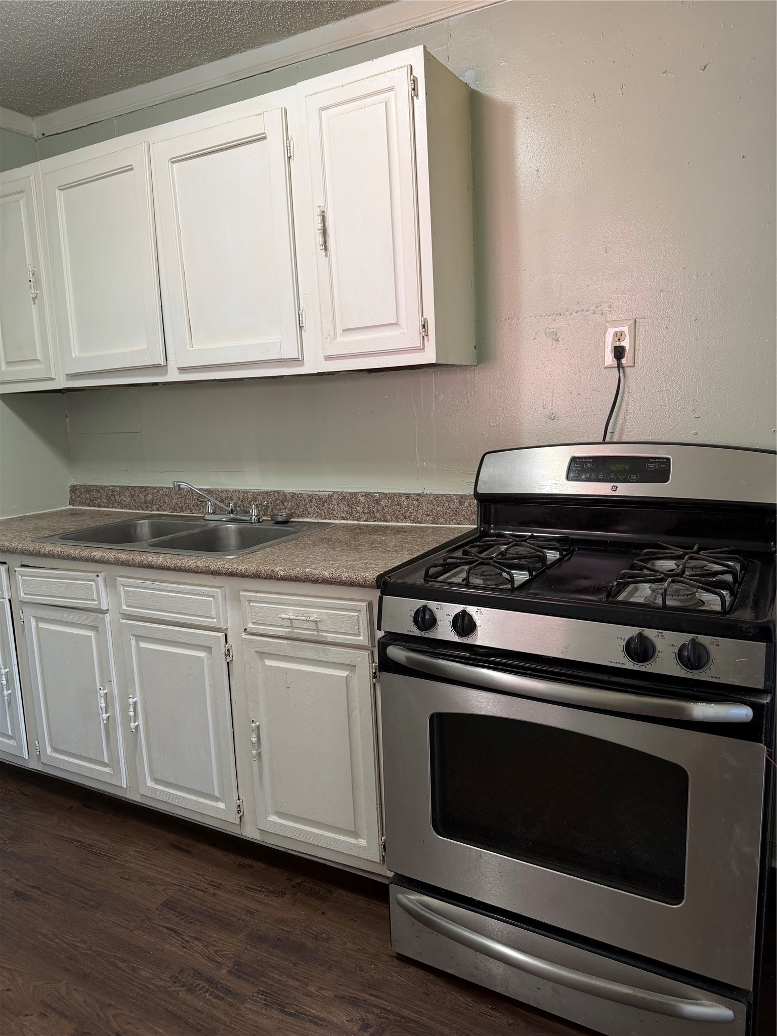 11914 Anchick Street Houston, TX 77076 - Photo 16 of 17 a kitchen with granite countertop white cabinets and appliances