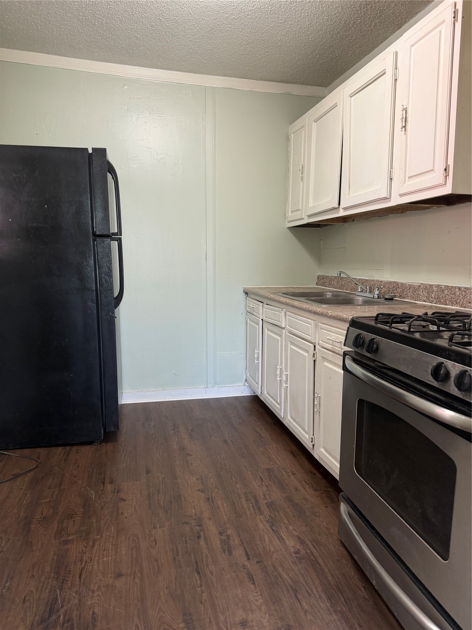 11914 Anchick Street Houston, TX 77076 - Photo 17 of 17 a kitchen with stainless steel appliances granite countertop a stove a refrigerator and a microwave