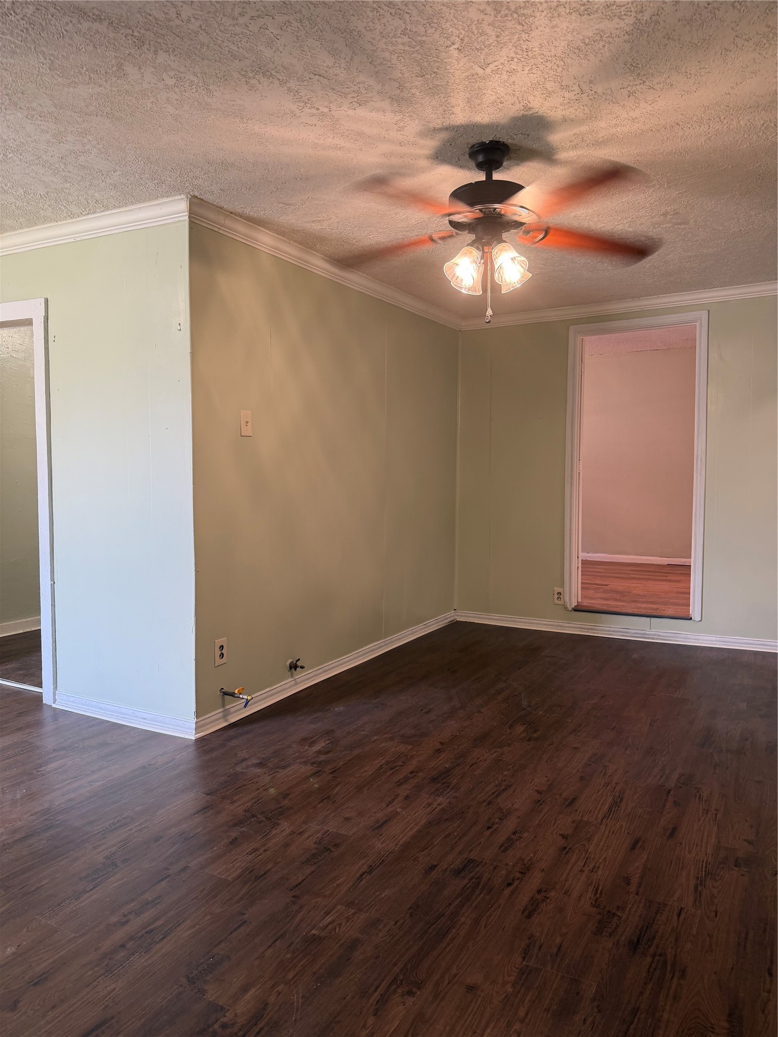 11914 Anchick Street Houston, TX 77076 - Photo 7 of 17 a view of an empty room with wooden floor and a ceiling fan