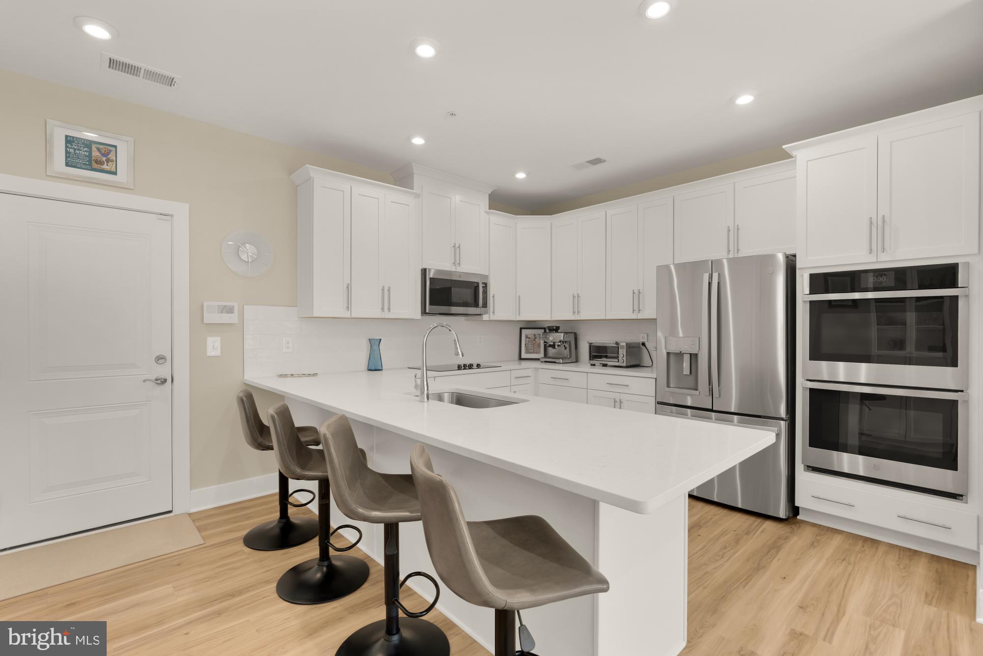 1704 Bandit Loop, Unit 20A Reston, VA 20190 - Photo 6 of 32 a kitchen with stainless steel appliances a table chairs refrigerator and microwave