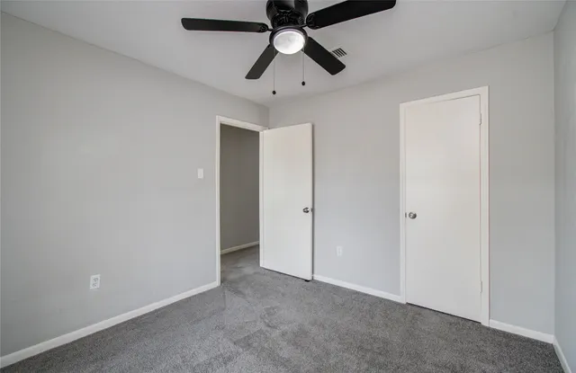 an empty room with chandelier fan