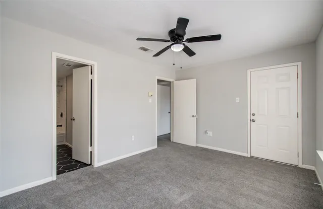 a view of a livingroom with a ceiling fan & windows