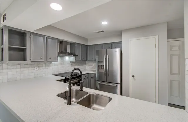 a kitchen with a refrigerator a sink and cabinets