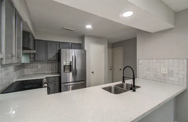 a kitchen with a refrigerator and a sink