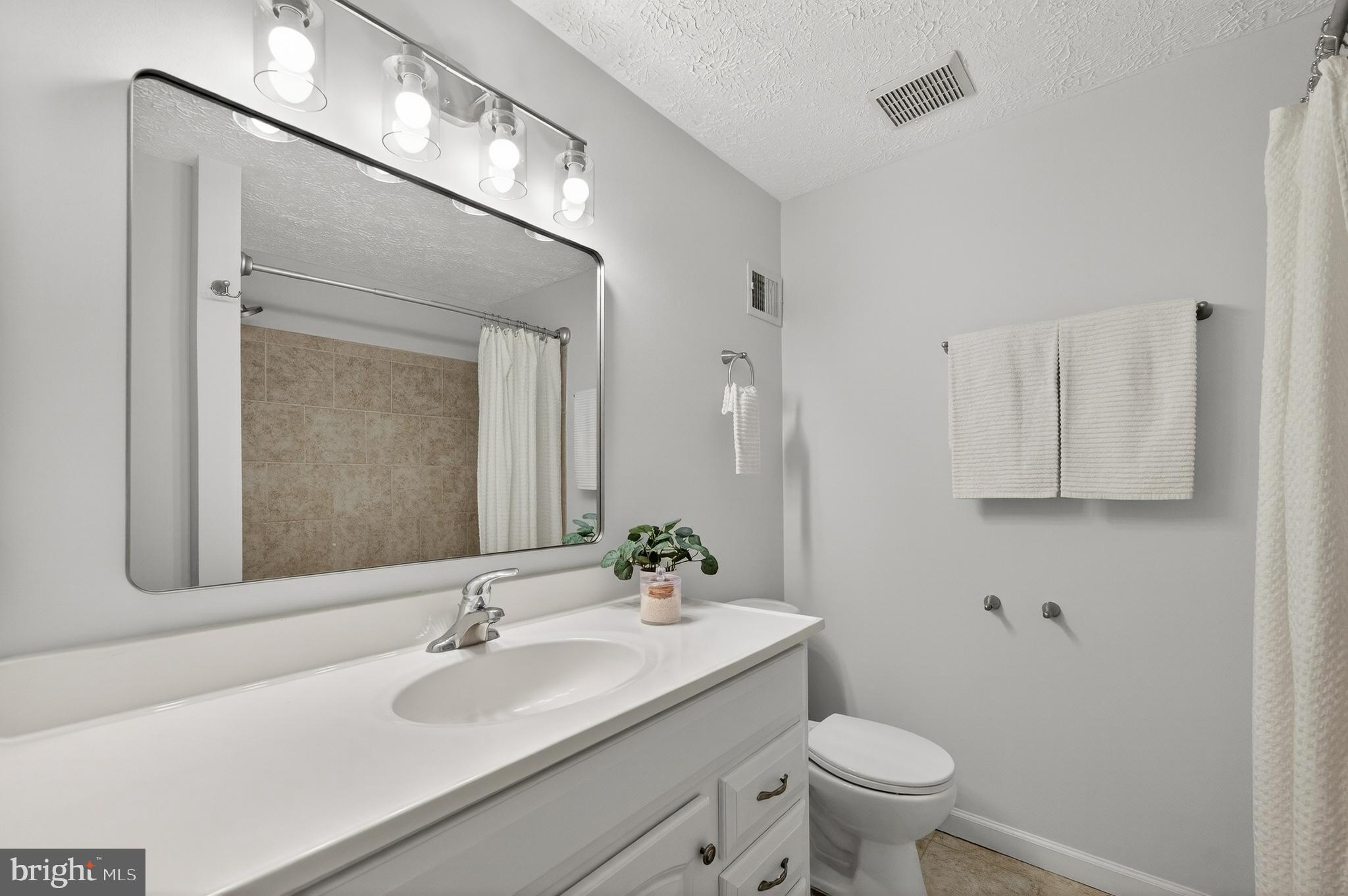 8225 Burning Forest Court Springfield, VA 22153 - Photo 26 of 43 a bathroom with a granite countertop sink a toilet and a mirror