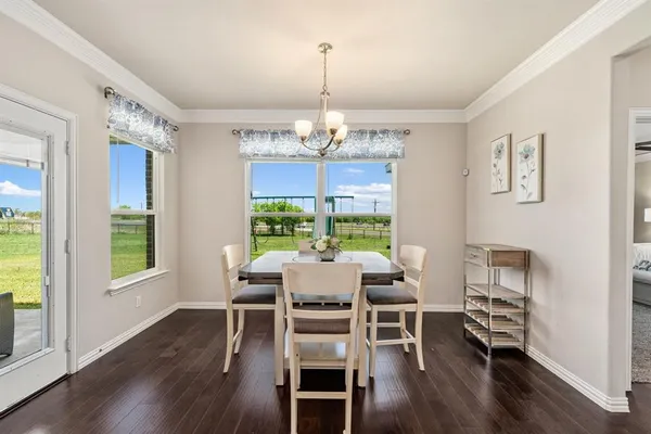 a kitchen with white cabinets and window