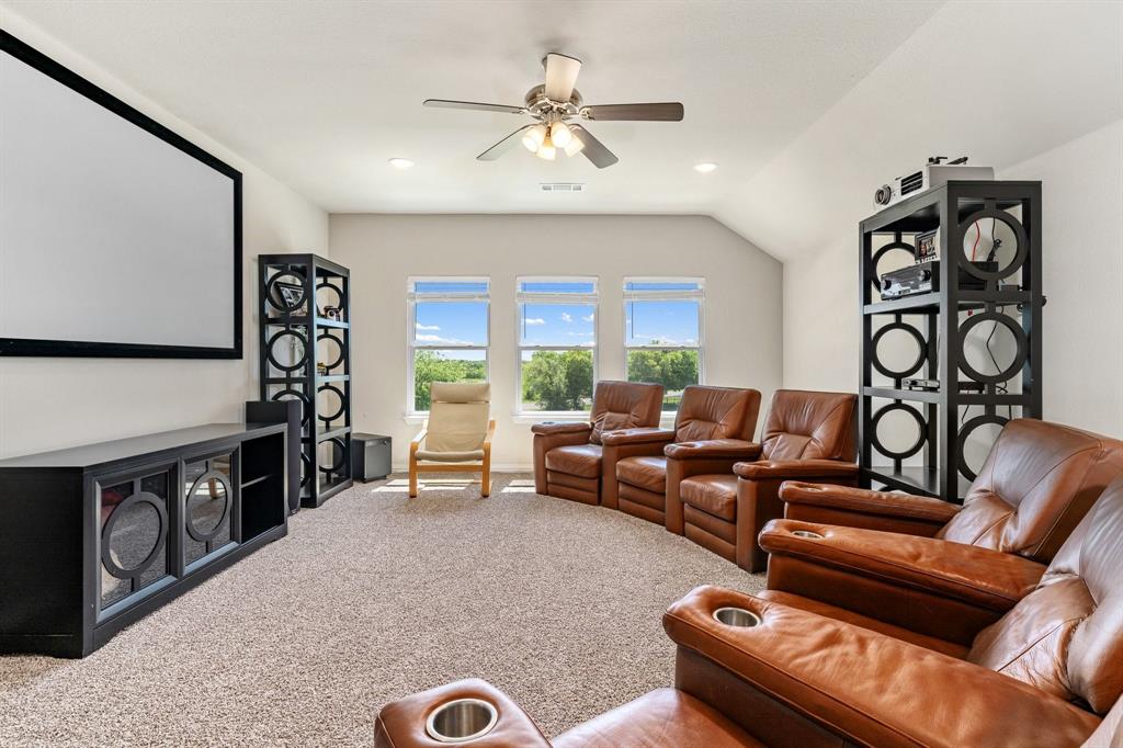 12700 Cold Spring Lane Ponder, TX 76259 - Photo 17 of 30 The upstairs bonus room can serve as a media room with a ceiling fan and wall-to-wall premium carpeting.