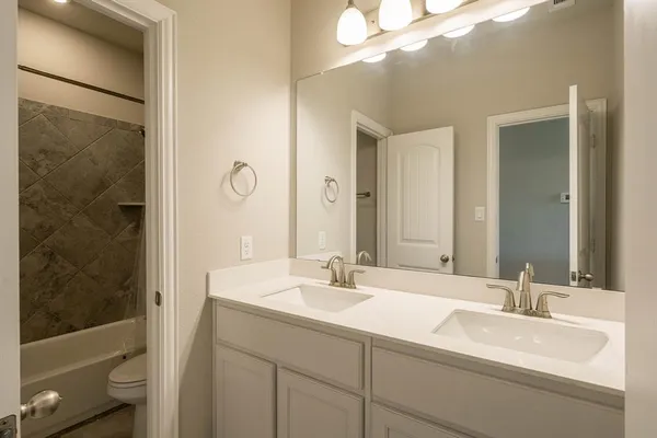 a bathroom with a sink toilet vanity and shower