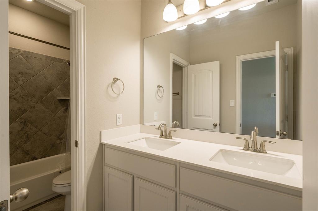 12700 Cold Spring Lane Ponder, TX 76259 - Photo 19 of 30 Secondary bath with dual sinks and sleek vanities.