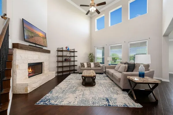a living room with furniture a flat screen tv and a fireplace