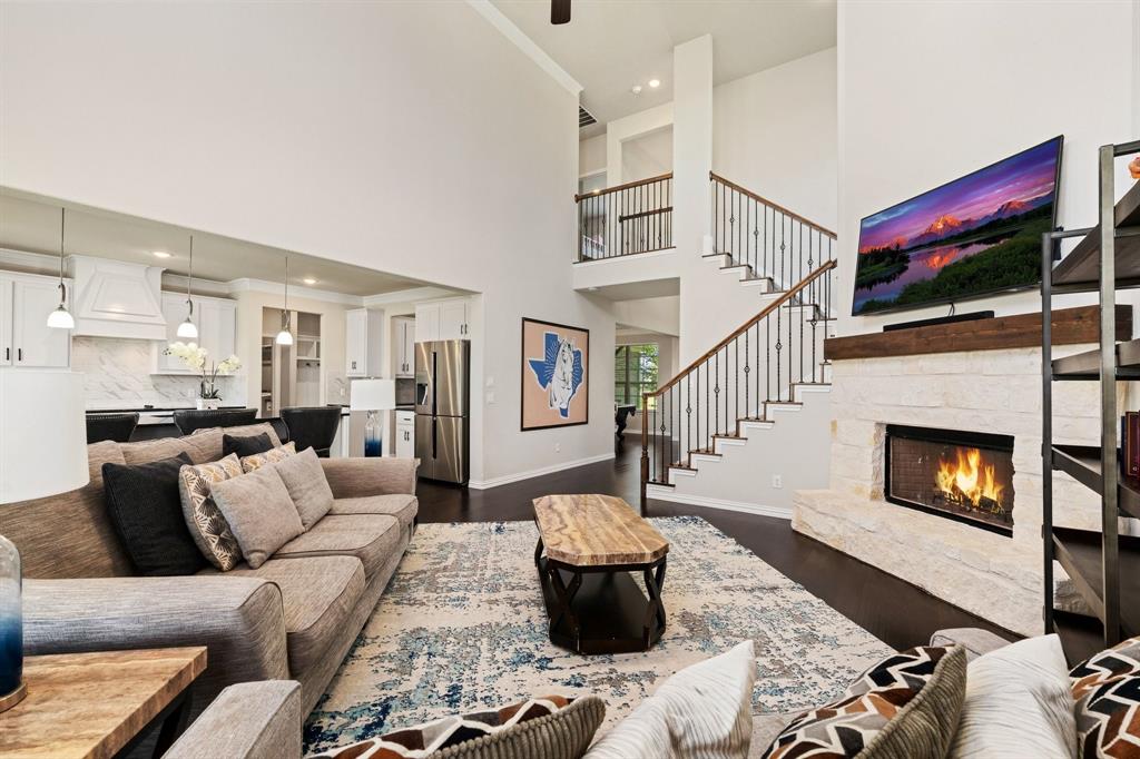 12700 Cold Spring Lane Ponder, TX 76259 - Photo 8 of 30 The Family room has a focal stone fireplace, wood floors, and a central staircase.